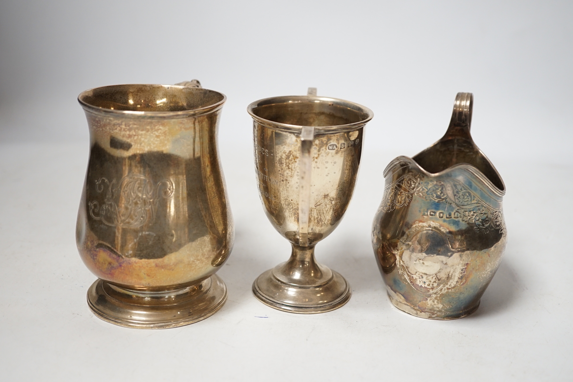 A George III silver cream jug, London, 1806, a George III silver half pint baluster mug, London, 1769 and a later silver two handled trophy cup, 13.7oz.